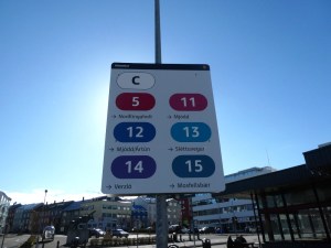 The sign at Hlemmur stand C, showing the six bus routes that stop here and which direction they're going. The sun is directly behind the sign which is just a little silhouetted.