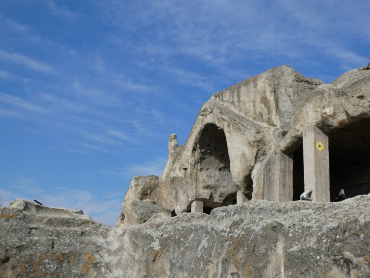 The front of the semi-open-air theatre with concrete pillars holding up the ancient stone ceiling.