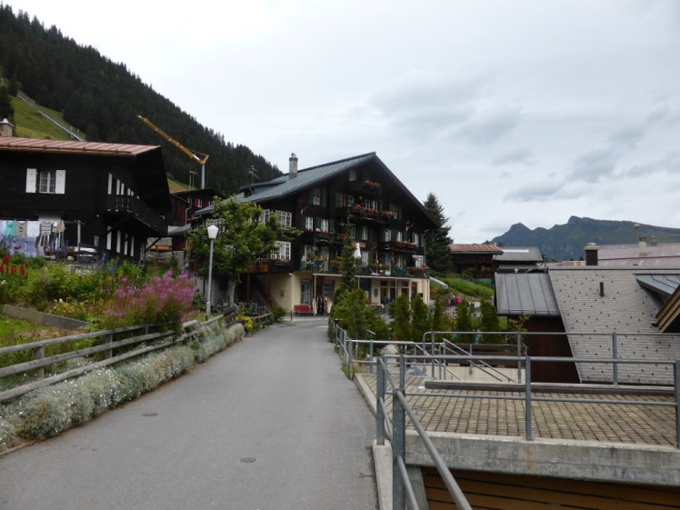 Walking through Murren. It's a pretty Alpine village, all traditional chalets and flowers but it's narrow and the pavement has rails to keep you from falling into gardens on a slightly lower tier.