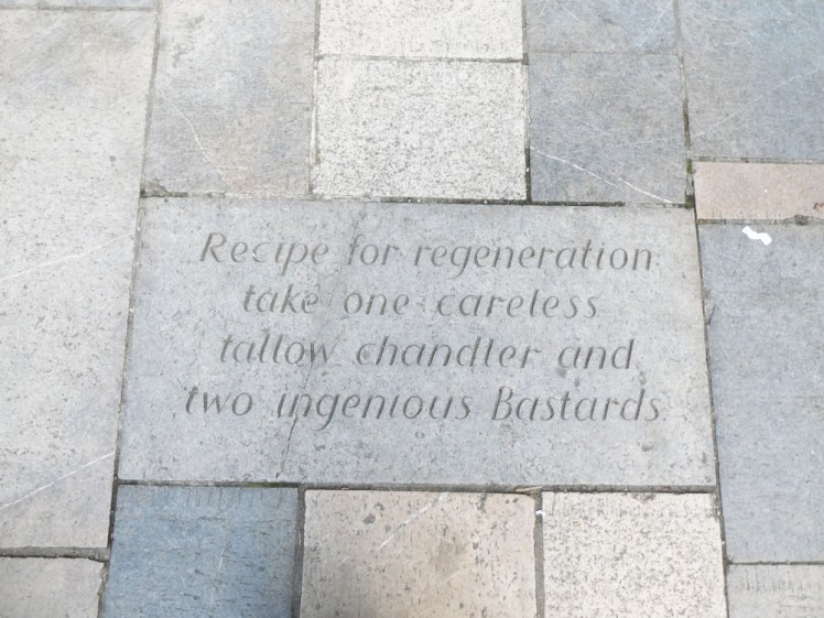 A stone plaque in the pavement with the words 