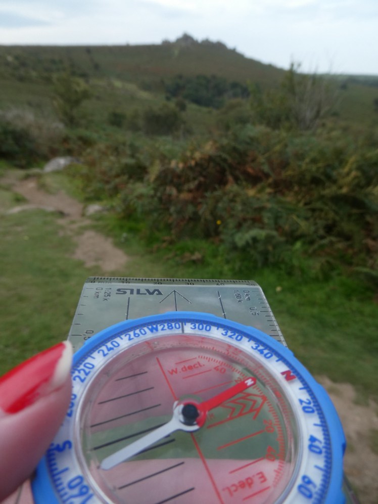 Pointing my compass at Hound Tor, with the bezel turned so the red arrows line up.