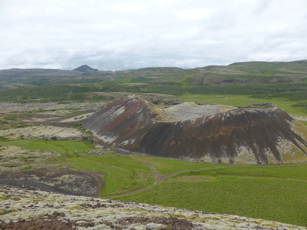Looking across to Grábrók, a smaller crater with barer sides, sitting in a grassy field a couple of hundred metres away from Big Grábrók where the photo is taken.