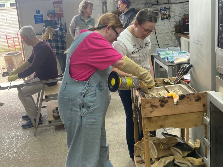 Blowtorching the paperweight with a gas-powered torch.