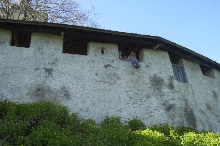 The same wall seen from the outside and below. It's stone but painted white with a thatched roof. It's not very high but it's high enough that I wouldn't be sitting with my feet hanging over the edge like Jemma is.