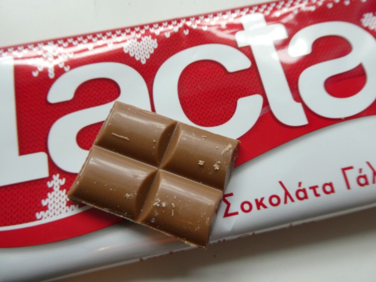 A close-up of Lacta's red and white "knitted" package with four squares of slightly pale chocolate on top.