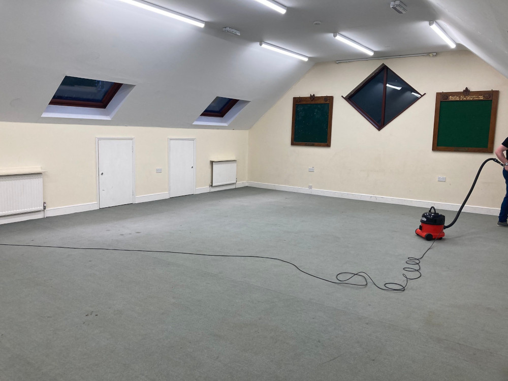 The terrarium end of the big upstairs room. The tables have been removed and Tom, just off the edge of the photo, is hoovering up gravel and soil with a red Henry hoover.