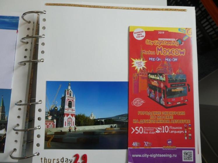 A genuinely quiet page. There's a photo of a church on the left and a fold-out map of the tourist bus on the right. At the top is a strip of gold decoration and at the bottom the date in red and gold letters.