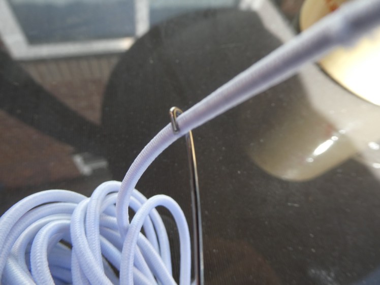 Elastic hooked on the end of the pole threader