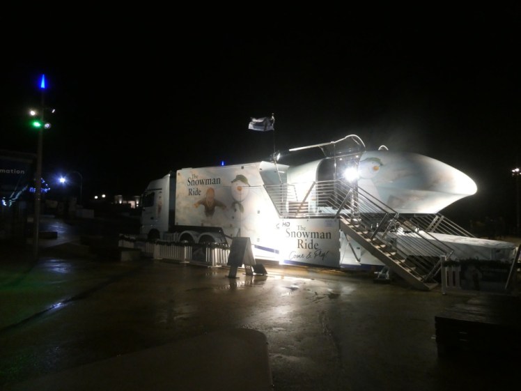 A flying simulator on the back of a lorry branded with Raymond Briggs' The Snowman.