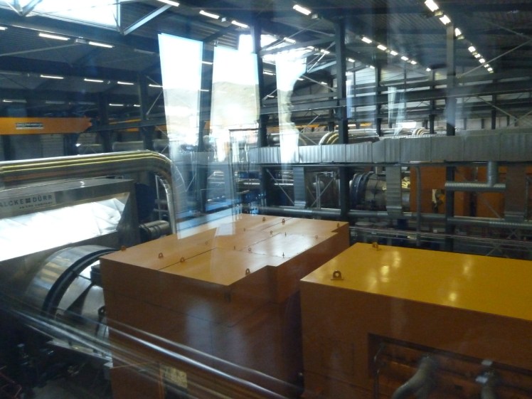 Turbines inside Nesjavellir geothermal power station. They look like square orange steel boxes.