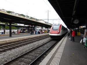 The train to Yverdon arriving in the station at Neuchatel. It's a gleaming white tilting train with a red nose.