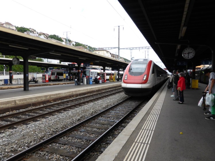 The train to Yverdon arriving in the station at Neuchatel. It's a gleaming white tilting train with a red nose.