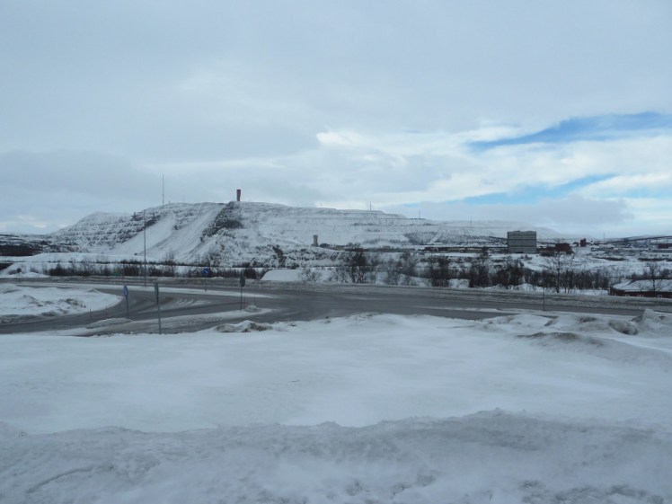 A snow-covered mountain in the distance. In the foreground is a field of slippery-looking ice. The mine is hiding on the other side of the mountain.