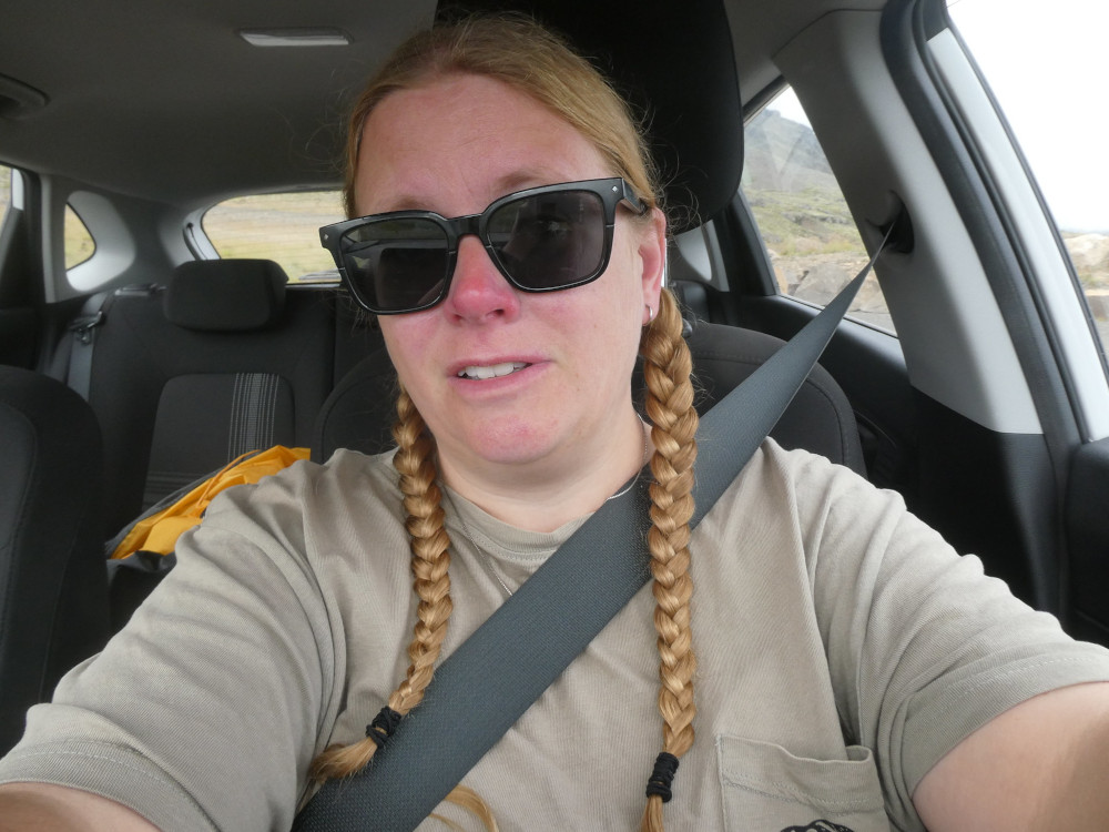 A selfie in the car. I'm wearing a grey-green Taylor Swift reputation tour t-shirt and my sunglasses. You can just see my yellow tent behind me.