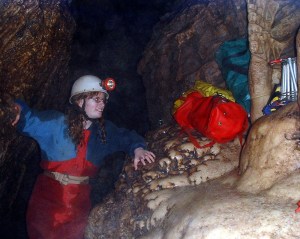 Me in Swildon's Hole in 2004, wearing a red and blue caving oversuit that's visibly very wet in most places.