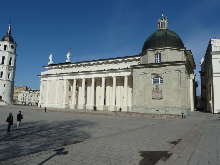 Vilnius Cathedral, a mostly rectangular white building with colonnades down the side, a low dome over a greyer building attached to one end and a free-standing bell tower a few metres away at the other end. It's very much not Gothic. I don't know what it is.
