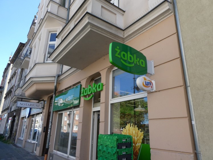 A Zabka mini convenience store, with a green sign. These are everywhere in Polish cities.