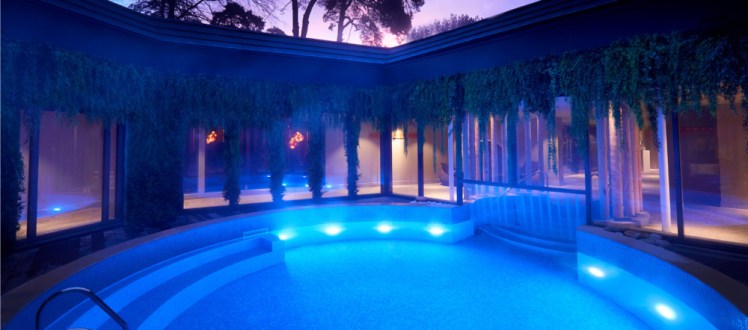 The central outdoor circular pool, glowing blue under a pale evening sky.