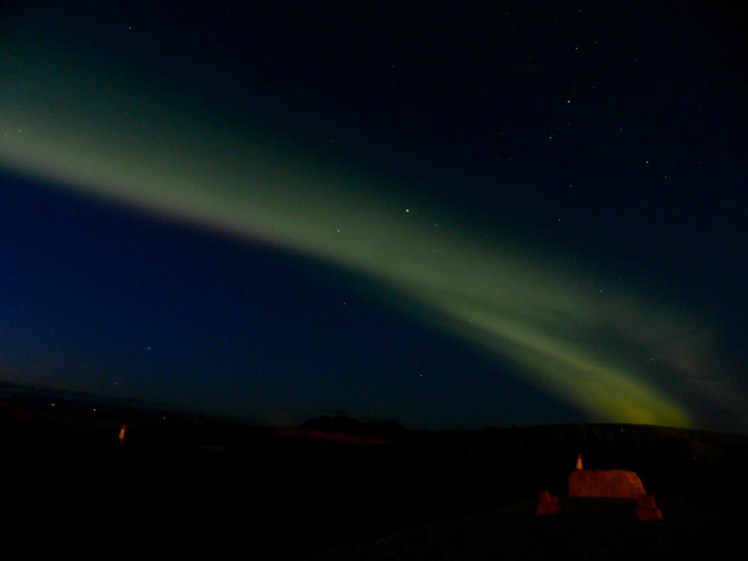 The Northern Lights - a streak of green running across the sky and disappearing behind the horizon. It's neither as bright nor as dramatic as in many photos you'll see because this is what you'll actually see, if you see anything at all.