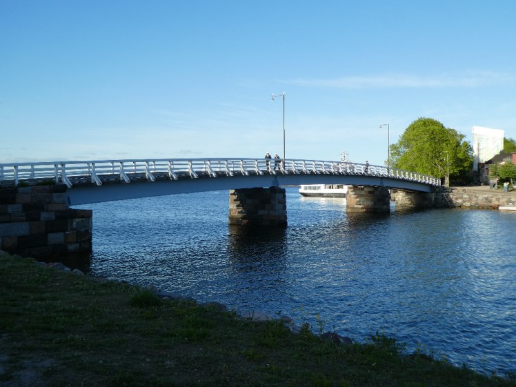 A white wooden bridge arching gently across between two of Suomenlinna's islands.