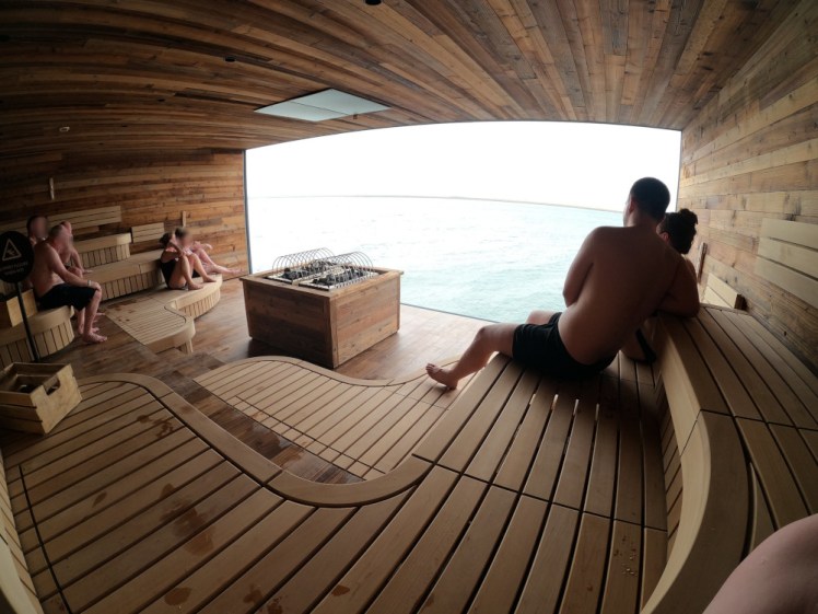 The Sky Lagoon sauna: a wooden room with one wall made up entirely of a huge window with sea views.