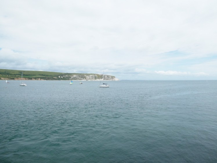 Swanage Bay, a great sweep of blue water bordered opposite me by grassy chalk cliffs.