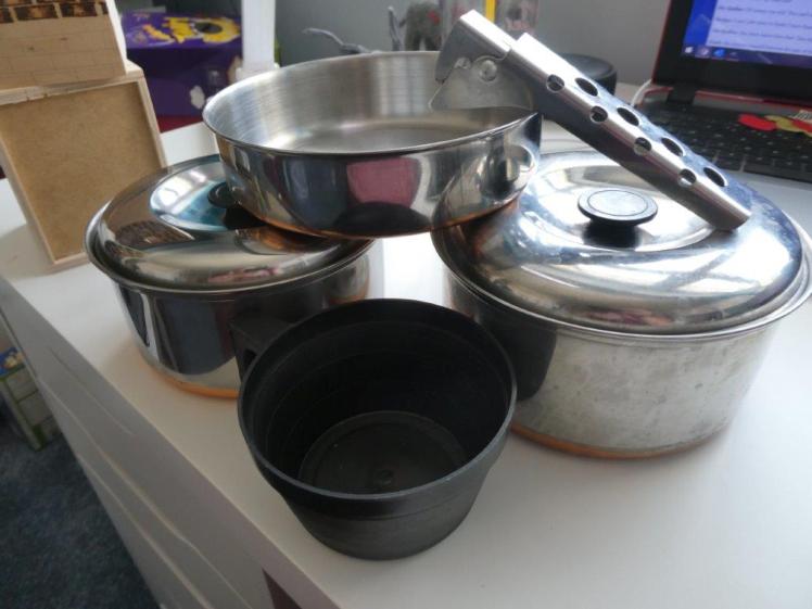 Vango aluminium cookset. Two smallish saucepans with lids and a deep frying pan, a plastic cup and a handle that all packs down together into the biggest pot.
