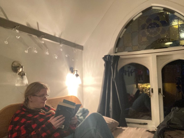 Me sitting on the bed reading a book. The curtains are open and it's dark outside and I look exactly as fake & posed as I am. But I did read in the hut!