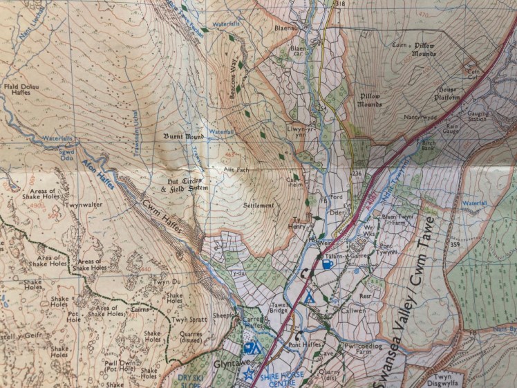 A photo of my 1:25 000 OS map. Coming off the red road running down the right side is a green diamond track leading along the contours of a very steep mountain. Our route goes directly across those contours on a route not marked on this old map.