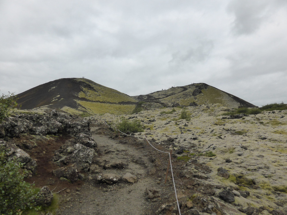 A rough path with a rope next to it leading up to the saddle-shaped Big Grábrók