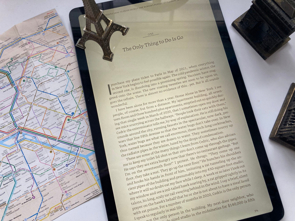 The first page of the first chapter of I'm Mostly Here to Enjoy Myself, a bit closer up than the previous picture and now the mini model Eiffel Tower is sitting on the tablet.