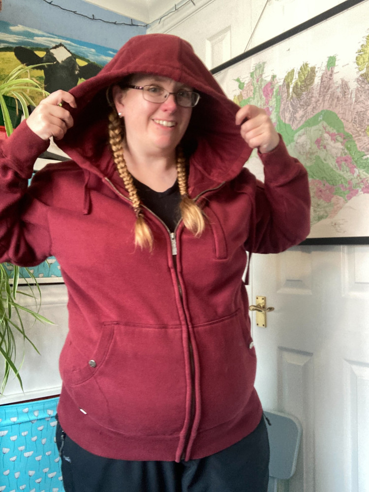 Me in my office wearing the dark red hoodie with all the pockets. I'm holding the huge hood open above my head.