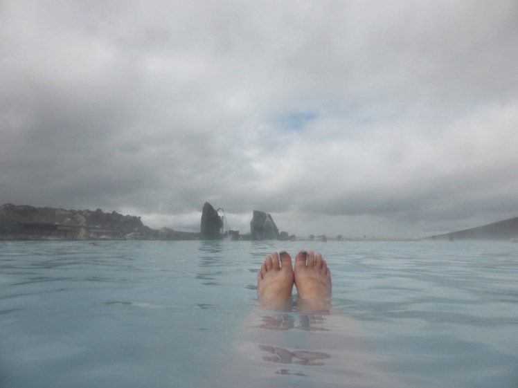 My feet sticking out of the hot, blue, slightly opaque water of the Myvatn Nature Baths.