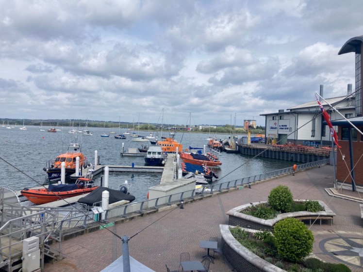 The view from the cafe at the RNLI College, overlooking the side of the ALC and various lifeboats moored on the harbour next to it.