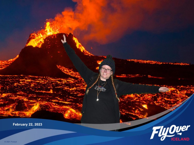 Me with my arms outstretched as if I'm flying. I've been superimposed over a photo of an erupting volcano and at the bottom is a blue swoosh with the FlyOver logo and date.