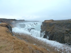 Gullfoss in October, a winter-turquoise and white waterfall set in a deep golden-brown sided chasm.