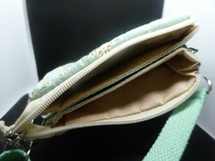 Inside the original bag - the top zips open to reveal three open-topped pouches hiding inside - two bags sewn back to back with the gap between forming the third pouch.