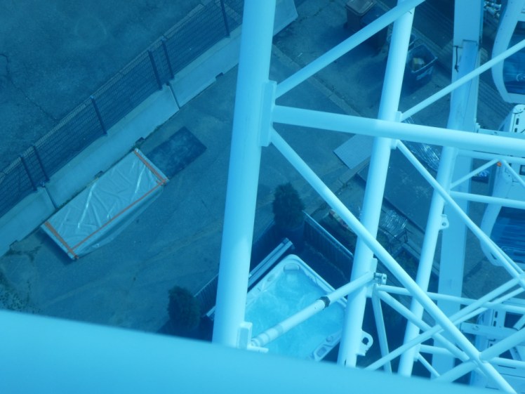 The hot tub seen through the blue windows and through the metalwork of the wheel, from a good ten metres above.