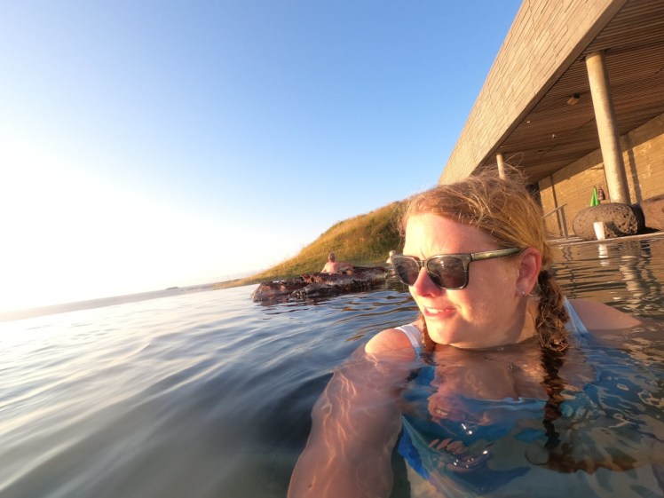 Me sitting against the side of the pool with golden evening light straight on my face.