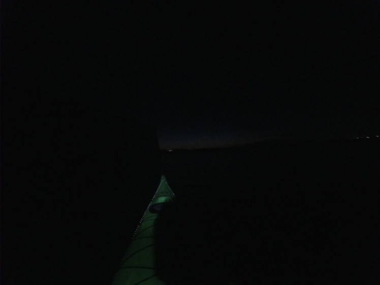 The glow of Poole Quay behind the hill in the distance