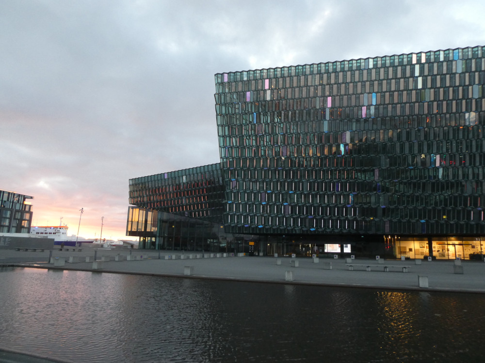 Harpa, a concert hall vaguely rectangular in shape but with all its sides made of six-sided green glass panels. There are light tubes hiding inside which make the panes shimmer in different colours.