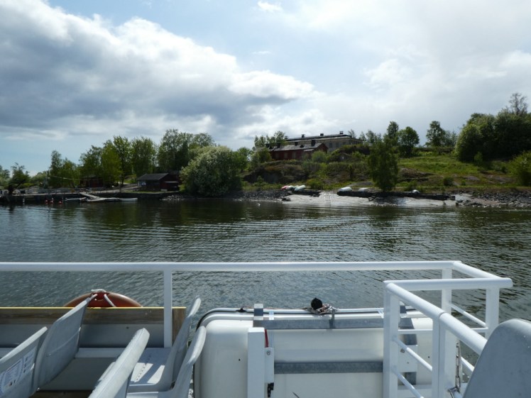 An island with lots of trees and topped by a large house. This is one of the islands used as an art retreat.