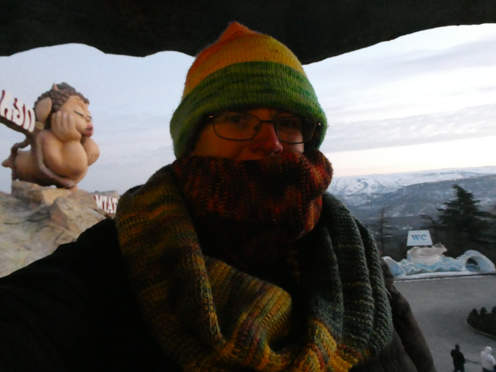 A selfie in the tree structure at the entrance to Mtatsminda Park. I'm mostly in shadow but you can see my scarf is now pulled up over my mouth because it's cold.