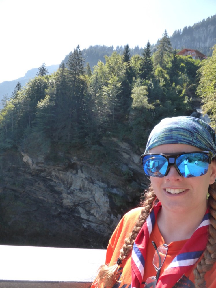 A selfie with the waterfall, showcasing my huge ugly blue mirrored sunglasses, orange t-shirt and red international neckerchief.