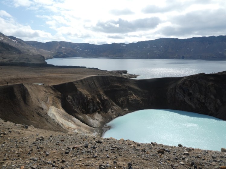 A smallish but steep-sided deep crater flooded with opaque blue-white water. Separated from this by a relatively thin wall of rock is a much bigger lake, clear and dark blue and contained within a ring of mountains.