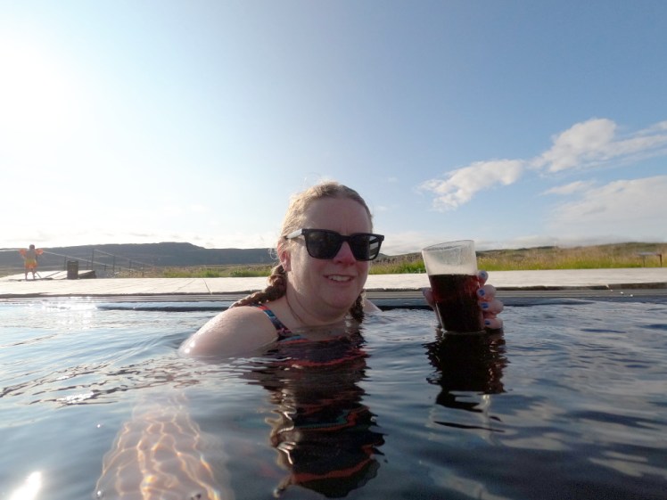 Me, silhouetted a bit behind a low sun, drinking a plastic cup of Coca Cola in the hot pool.