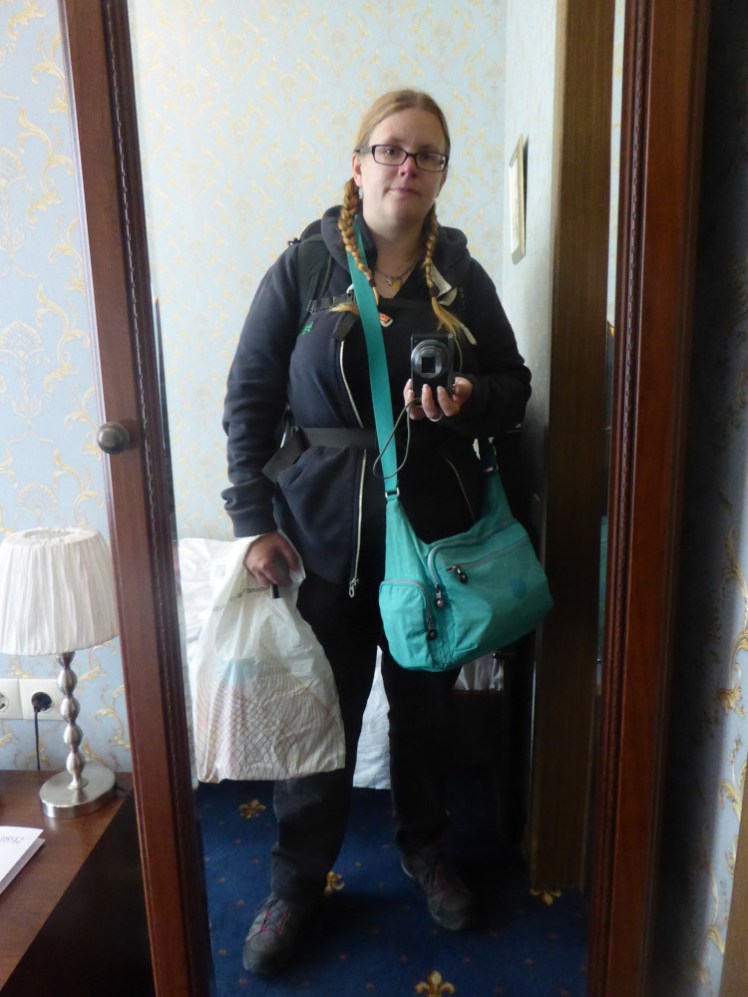Another hotel mirror selfie, this one on my last morning in Moscow. I'm wearing black trousers and a black t-shirt under a navy hoodie. You can't really see it but I'm wearing that same 45l backpack. I'm also wearing a large mint green handbag that I wish I'd never taken, and I'm carrying a plastic carrier bag. This is not how hand luggage is supposed to work.