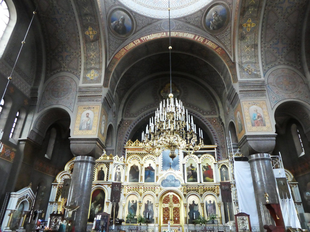 Inside Uspenski Cathedral. There's a huge gold altar piece filled with icons and the walls, ceilings and arches are a brownish-grey colour but filled in with intricate patterns, gold and more icons.
