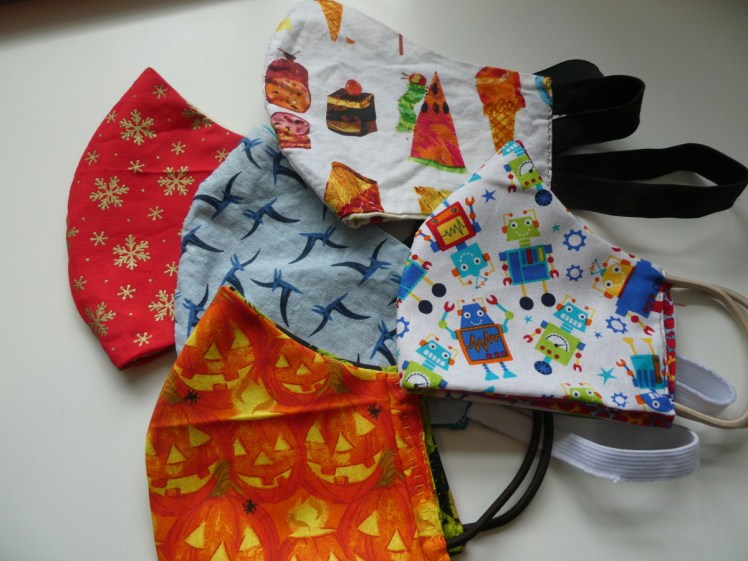 My fun fabric mask collection: dinosaurs, snowflakes, pumpkins, robots & Hungry Caterpillars.