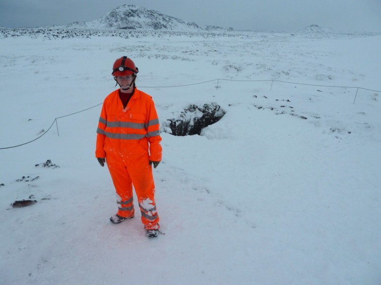 Me in my boiler suit next to the cave in the snow